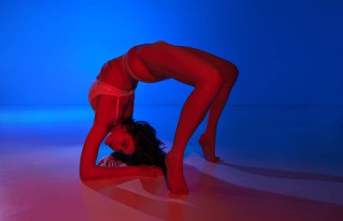 Zarafet ve neon enerji. Genç çıplak kadın poz veriyor. Köprüde duruyor. İç çamaşırları içinde. Sanat anlayışı, kadın sağlığı, sağlık, kendini ifade etme.