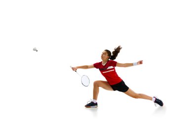 Atletizm ve kararlılık. Profesyonel bayan badminton oyuncusu beyaz stüdyo geçmişine karşı hareket halinde. Spor anlayışı, aktif yaşam tarzı, güç ve güç, eylem. Boşluğu kopyala.