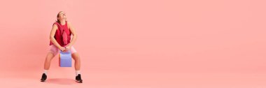Pankart. Kağıt cepli genç bayan eğitimi pastel pembe arka planda mesaj için negatif alan. Spor anlayışı, aktif yaşam tarzı, sağlıklı beslenme, zindelik, enerji.