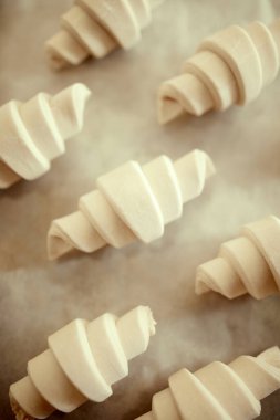 Yakın çekim, tatlı ya da lezzetli hamur işleri, ahşap masa üzerine kruvasan hamuru parçaları parşömenle kaplı. Doğa kavramı, yemek, diyet, yemek ve yemek tarifleri, beslenme, fırın.