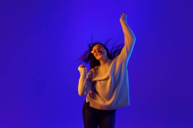 Modayı takip eden güneş gözlüklü genç bir kadının dinamik portresi enerjik bir şekilde ritmik bir şekilde hareket ediyor ve saçları hareket halinde gelişiyor. Güzellik anlayışı, moda, gençlik, satış. Dans eden güzel bir kadın.