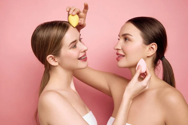 Makeup-Free Affirmation. Young girls stand united without makeup and uplifting each other through simple joy of applying makeup together. Concept of beauty treatment, cosmetic product.