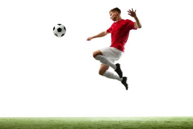 Mükemmel bir tekme. Profesyonel futbolcu topu havada süzülüyor, zamanda donarak beyaz zemine karşı yeşil alanla birlikte. Spor oyunları, hobi, enerji, hareket kavramı. Ad