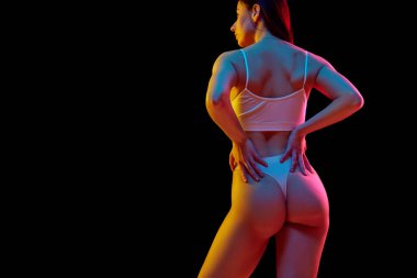Anti-selülit programı. Formda kadın vücudunun arka plan fotoğrafı, sağIıklı sırt ve kalça, neon ışıkta siyah stüdyo arka planına karşı. Sağlık, kilo kaybı, tedavi, sağlık hizmetleri, sağlık hizmetleri
