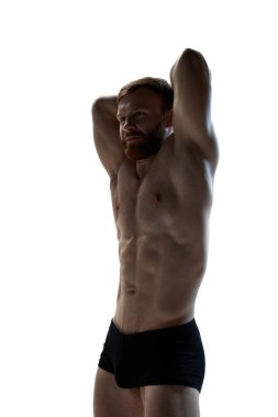 Sakallı çekici bir genç beyaz arka planda mükemmel gövdesini gösteriyor. Erkek model pozu. Doğal güzellik kavramı, estetik beden, erkek sağlığı, erkeklik..