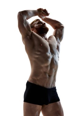 Genç ve çekici bir adam beyaz arka plana karşı mükemmel vücut şeklini gösterdi. Diyet ve zindelik. Spor ve spor. Doğal güzellik, sanat, erkek sağlığı, erkeklik kavramı. Ad