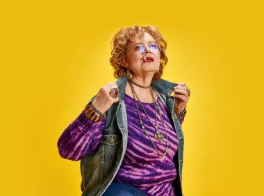 Çekici, hayat dolu bir kadının portresi. Eski moda kıyafetler ve eski mücevherler gibi poz veren. Daha yaşlı yetişkinlerin, modern hayatın aktif yaşlılarının, moda ve tarzın güçlendirilmesi kavramı.