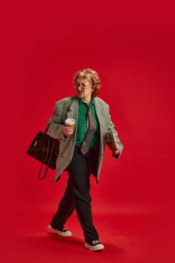 Zarif giyinmiş, işe yürürken birine bağıran olgun bir kadının tam boy portresi. İş anlayışı, modaya uygun yaşlı yetişkinler, modern hayatın aktif yaşlıları, moda ve tarz.