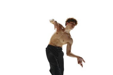 Yarı çıplak, siyah pantolonlu erkek balerin beyaz stüdyo arka planında çağdaş dans anında donar. İnsan hareketleri, sağlık anlayışı, erkek vücudunun doğal güzelliği..