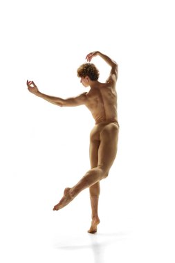 Noktalı adam. Beyaz stüdyo arka planında donan genç, atletik erkek balerin portresi. Modern bale, sanat, hareket, aksiyon, ilham kavramı.