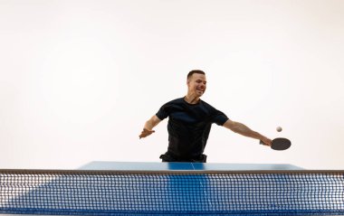 Atletik adamın dinamik portresi beyaz stüdyo arka planına karşı hızlı masa tenisi oyununa girdi. Uzayı kopyala Profesyonel spor, dinamik ve enerji kavramı, şampiyonluk, turnuva. Ad.