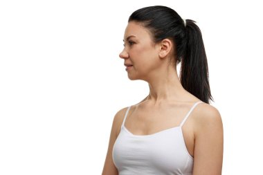 Çekici orta yaşlı esmer kadının profil portresi beyaz stüdyo arka planına bakmadan gülümsüyor. Yüz bakımı, güzellik, kaplıca, kozmetoloji, cilt bakımı, yaşlanmayı önleme.