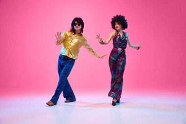 Ritim 'de kayboldum. Genç bir çift, parlak retro kostümlü bir kadın ve erkek dans ederken gradyan pembe stüdyo geçmişine karşı poz veriyorlar. Amerikan kültürü kavramı, 70 'ler, 80' ler moda, müzik, dönemin karşılaştırmaları..