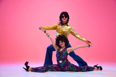 Ritim 'de kayboldum. Genç bir çift, parlak retro kostümlü bir kadın ve erkek dans ederken gradyan pembe stüdyo geçmişine karşı poz veriyorlar. Amerikan kültürü kavramı, 70 'ler, 80' ler moda, müzik, dönemin karşılaştırmaları..