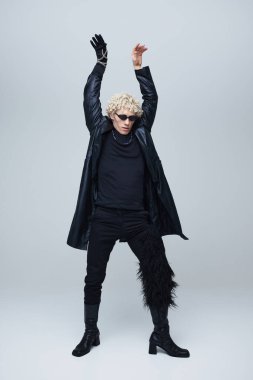 Tarz sahibi, yakışıklı genç adam dinamik duruşuyla gotik modaya modern bir bakış açısı sergiliyor. Moda birleşimi ve kendini ifade etme kavramına karşı tamamen siyah giyimli bir erkek model. Ad