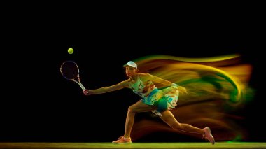 Canlı kıyafetli bir tenisçi siyah stüdyo arka planında hareket bulanıklığı olan forehand için hamle yapıyor. Kadınların spor anlayışı, aktif yaşam tarzları, turnuvalar ve etkinlikler, enerji, hareket.