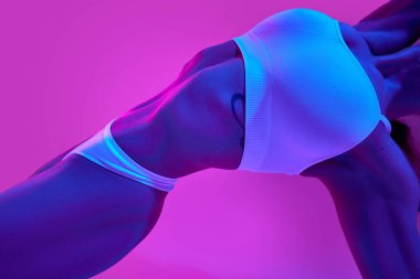 İnce kadın vücudu, karın ve göğüs. Beyaz iç çamaşırı modeli. Mavi neon ışıkta mor renge karşı. Güzellik, diyet, kadın sağlığı, kadınlık, spa prosedürleri kavramı