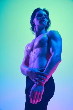 Çıplak gövdeli ve neon ışıklı genç bir adamın karışık gradyan stüdyo arkaplanına bakınız. Doğal güzellik insanları, fitness, erkek sağlığı ve refahı, erkeklik kavramı.