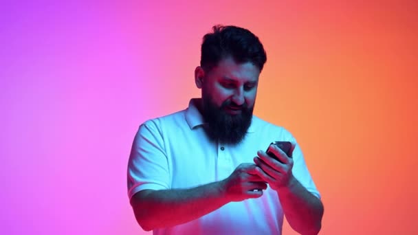 Young Bearded Man Looking Smartphone Victorious Expression Clenched Fist Success — Stock Video
