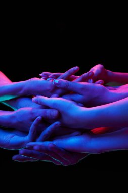 Siyah stüdyo arka planına karşı çok renkli neon ışıklı eller birlik ve destek işareti olarak birbirlerine sürtündüler. Sanat anlayışı, insan dokunuşu, güzellik ve bakım, spa prosedürleri..