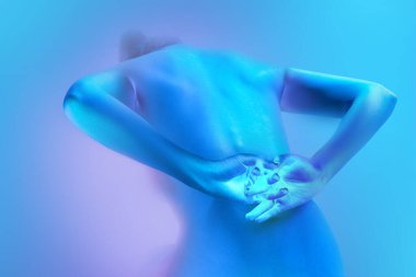 Arka planda çıplak genç bir kadının tablosu, el ele tutuşmuş, neon ışıkta arkaplandaki değişime karşı. Sanat ve kadınlık kavramı, kadın sağlığı, vücut bakımı, kendini ifade etme ve kendini sevme.