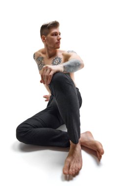 Dövmeli, yakışıklı, boklu, beyaz stüdyo arka planında poz veren genç adam. Uzayı kopyala Doğal güzellik, moda ve tarz kavramı, erkek sağlığı ve vücut bakımı. Ad