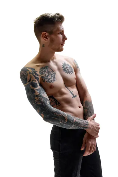 形象的纹身年轻英俊男子与肌肉身体看向别处的白色工作室背景 复制空间 自然美 时尚与时尚 男性健康与身体护理的概念 免版税图库照片