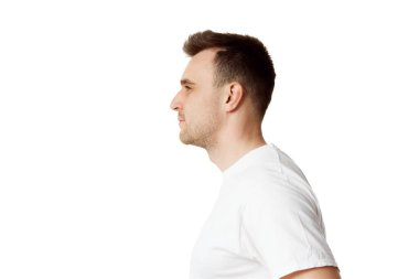 Beyaz atölyenin arka planında beyaz tişörtlü, sakallı esmer bir adamın yan görüş portresi. Doğal güzellik kavramı, spa tedavileri, erkeksi, kozmetoloji. Boşluğu kopyala