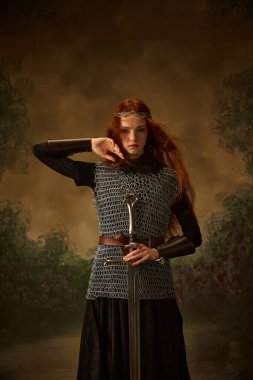 Zincirlenmiş genç prensesin portresi kılıçla vintage arka planda poz veriyor, cesur ve güzelliğini gösteriyor. Dönem, tarih ve modern zaman, güzellik ve moda karşılaştırmaları kavramı. Ad