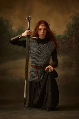 Savaştan önce sakin ol. Düşünceli savaşçı prenses, zincirli kadın ve uzun elbiseli klasik arka planda kılıçla diz çökmüş. Tarih ve modern zaman kavramı, güzellik ve moda. Ad