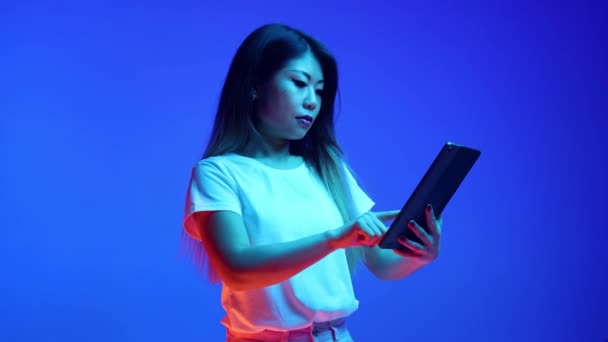 Young Attractive Asian Woman Using Digital Tablet Blue Gradient Background — Stock Video