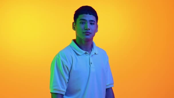 Jeune Homme Asiatique Avec Sourire Regardant Caméra Dans Une Lumière — Video