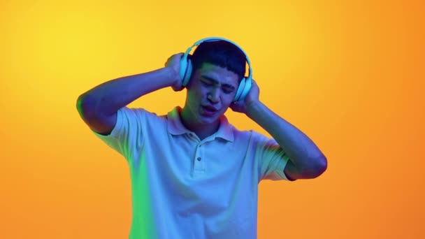 Jeune Homme Asiatique Dansant Écoutant Musique Dans Des Écouteurs Néon — Video
