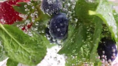 Tazeliğini ve doğal dokusunu ön plana çıkaran çiğ taneleriyle dolu canlı bir makro. Tatlı yazlar, cam içinde makro kabarcıklar içerler. Yiyecek ve içecek kavramı, beslenme, tazelik.