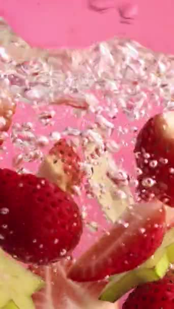 Нарізана Полуниця Зелене Листя Плавають Воді Світло Блакитною Соломою Рожевому — стокове відео