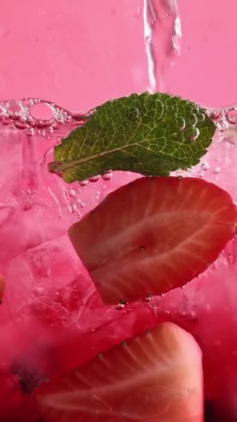 Krojone Truskawki Limonki Zielone Liście Pływające Wodzie Jasnoniebieską Słomką Różowym — Wideo stockowe