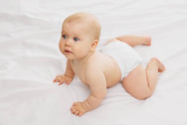 Huzurlu, bezli şirin bir bebek, erken çocukluk sükunetini somutlaştıran beyaz kumaş dokusuna dayanıyor. Çocukluk kavramı, annelik, yaşam, doğum. İlan için alanı kopyala