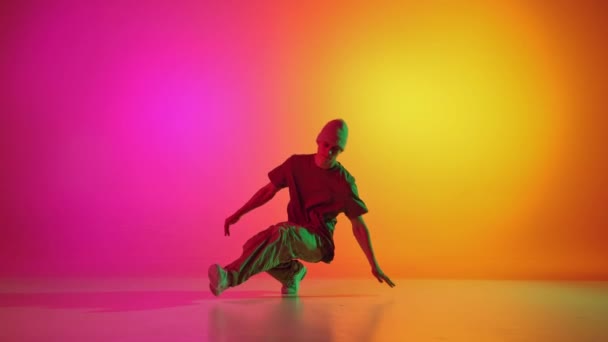 有才华的独唱歌手 男霹雳舞者在霓虹灯下表演嘻哈 背景呈深红黄色 业余爱好 时尚和风格 行动的概念 — 图库视频影像