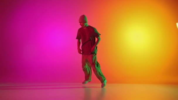 有才华的霹雳舞者在霓虹灯下 在渐变的粉色和黄色背景下跳舞 业余爱好 动作的概念 — 图库视频影像