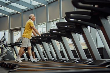 Kardiyo eğitiminden yağ yakmaya. Neşeli yaşlı yetişkinler, erkek ve kadın, spor salonunu mizahla eğlenceli hale getirir. Spor anlayışı, modern hayatın aktif yaşlıları, sağlıklı yaşam tarzı. Ad