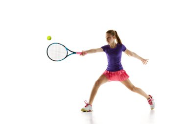 Tenis yetenekleri. Atletik genç kızın dinamik portresi beyaz stüdyo arka planında rakiplerine mükemmel bir şekilde hizmet veriyor. Profesyonel spor, hareket, turnuva, aksiyon kavramı. Ad