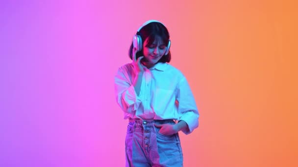 Femeie Tânără Costume Supradimensionate Ascultând Muzică Căști Dansând Lumină Neon — Videoclip de stoc