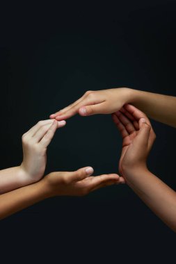 Bir bütün. Çeşitli çocukların elleri siyah arka planda daireler çiziyor. Irksal eşitlik ruhu. Birlik. Gençlik, ifade, güzellik, duygular, jestler, sanat ve sembolizm kavramı, çeşitlilik. Ad