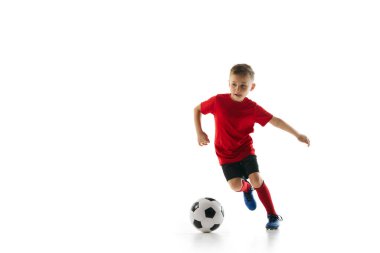 Üniformalı atletik, sportif çocuk, beyaz stüdyo geçmişine karşı hareket eden salya sürme tekniği. Dinamik çekim. Profesyonel spor, şampiyonluk, gençlik ligi, hobi. Ad