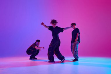 Spor kıyafetli, hip-hop yapan bir grup yetenekli çocuk karışık neon ışıklarını hareketli arka plana karşı kullanırlar. Spor ve hobi kavramı, müzik, moda ve sanat, hareket. Ad