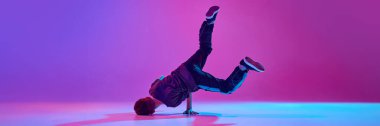 Pankart. Genç, break dansçı, parlak arka planda karışık neon ışıkta hareketli bir şekilde kafa üstü dönüyor. Uzayı kopyala Spor ve hobi kavramı, müzik, moda ve sanat, hareket. Ad