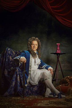 Özenle hazırlanmış barok tarzı giyinmiş yaşlı bir adamın portresi klasik stüdyo geçmişine karşı aristokrat gibi görünüyor. Dönem karşılaştırmaları, modernlik ve tarihin birleşimi. Ad