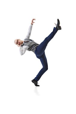 Resmi giyinmiş genç bir iş adamı, tek ayak üzerinde dengede duruyor ve beyaz stüdyo geçmişine karşı çağrıda bulunuyor. İş, iş ve öğrenim kavramı, hobi, serbest meslek, ofis. Ad