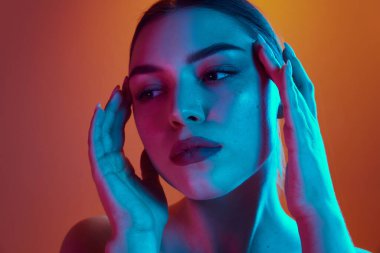 Yüzünün kenarlarına hafifçe dokunan genç bir kadının yakın plan çekimine. Güzellik ve bakım kavramı, kozmetik bilimi, sağlık, kaplıca tedavisi. Ad