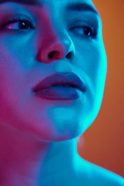 Tarafsız makyajlı genç bir kadının, arka plandaki eğime karşı karışık neon ışıkta poz vermesine yakın durun. Güzellik ve bakım kavramı, kozmetik bilimi, sağlık, kaplıca tedavisi. Ad